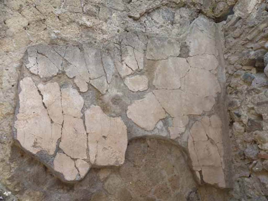 V. 10, Herculaneum, May 2010. Remaining plaster on east wall of shop-room.